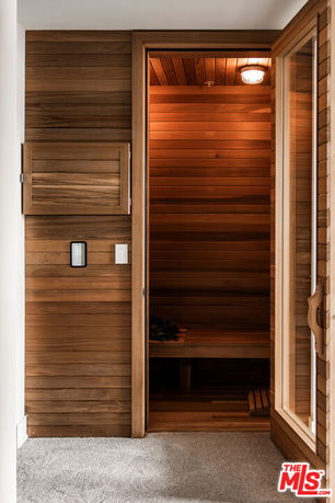 Interior view of a wooden sauna room with a glass door.