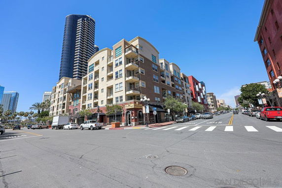 Street view showing the front of a multi-story residential building on a corner.
