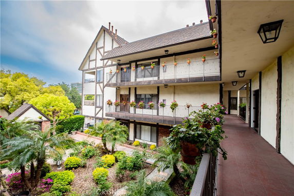 Exterior view of a multi-story building with balconies and decorative plants.