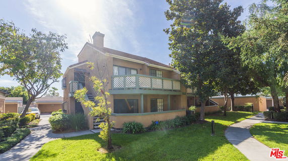 Front view of a two-story house with a balcony and chimney.