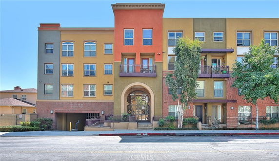 Front view of a multi-story apartment building with colorful facade and balconies.