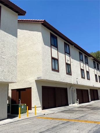 Front view of a multi-story building with garages on the ground floor.