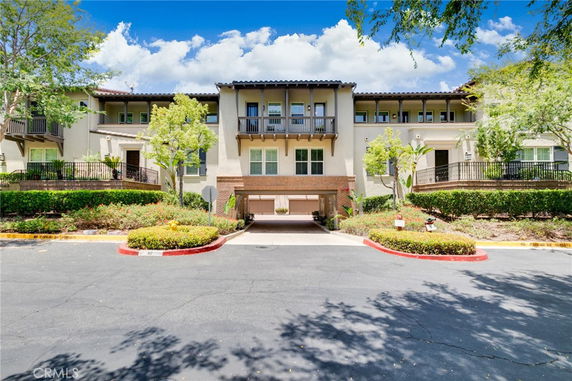 Front view of a two-story residential building with multiple balconies and a central garage.