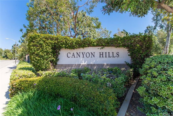 Entrance sign of a residential community named Canyon Hills surrounded by greenery.