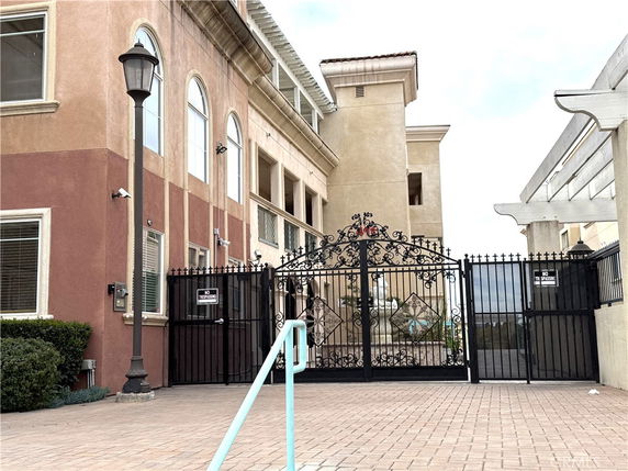 Front view of a building with ornate metal gate and arched windows.