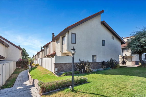 Front view of a multi-story townhouse with a sloped roof and chimney.