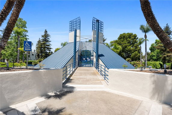 Front view of a building with a blue metal roof and accessible entrance ramp.