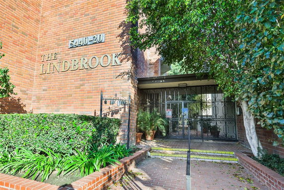 Front view of a brick building with a gated entrance and signage reading 'The Lindbrook'.