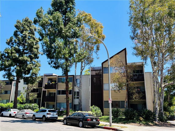 Front view of a multi-story apartment building with balconies.