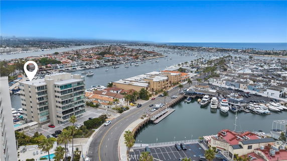 Panoramic view of a coastal area with buildings, roads, and a marina.
