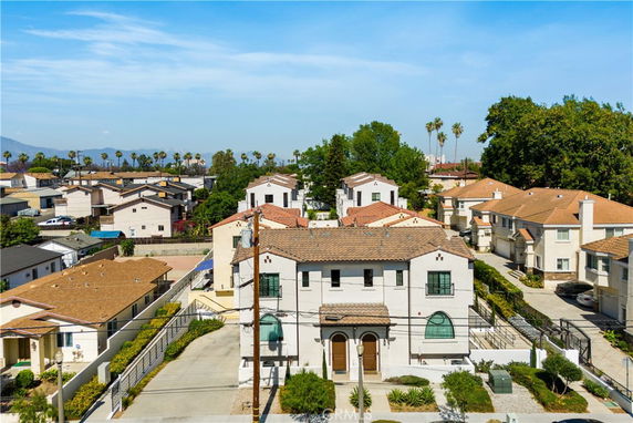 Front view of a two-story house with a driveway and arched windows.