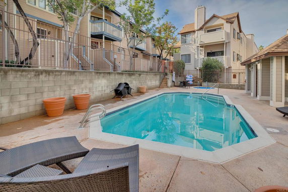 Outdoor swimming pool area surrounded by residential buildings.
