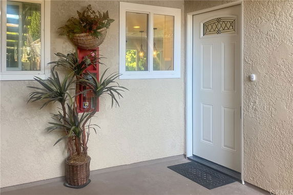 Front view of a house entrance with a white door and window.