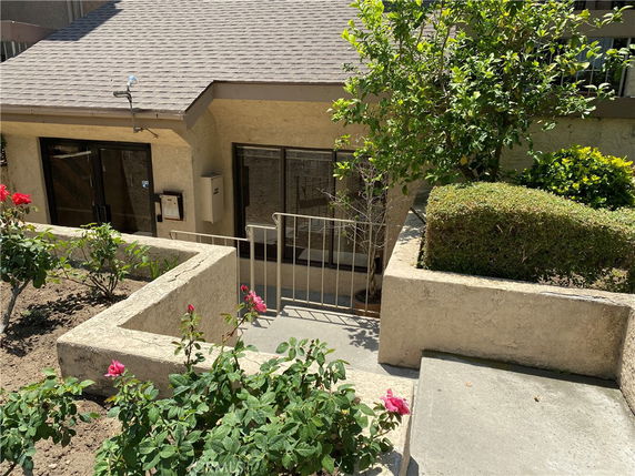 Front view of a house with a sloped roof and a small garden area.