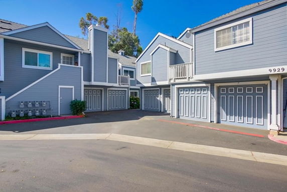 Front view of a residential building with multiple garages and a gray exterior.
