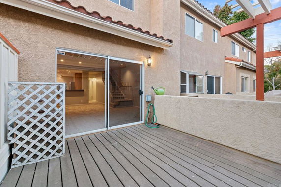 Front view of a two-story house with a sliding glass door and patio area.