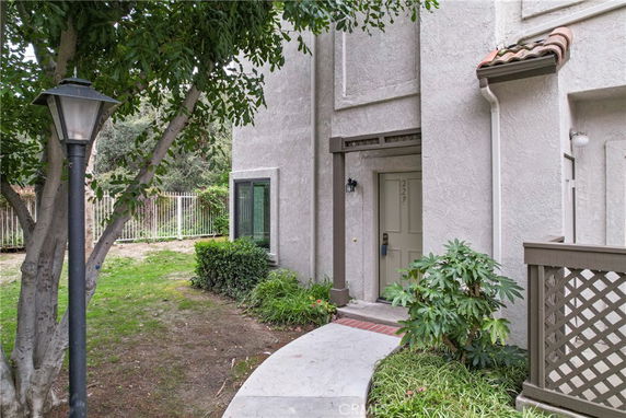 Front view of a two-story house with a walkway and greenery.
