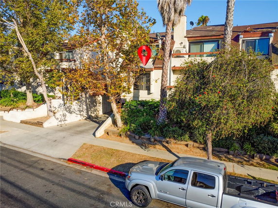 Front view of a multi-story house with trees and a driveway.