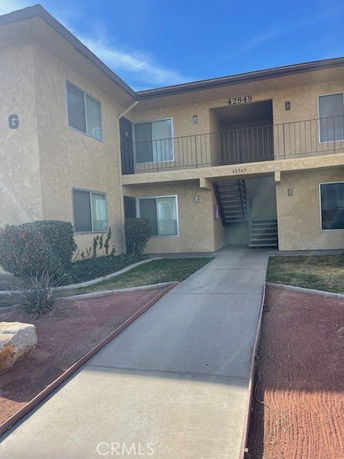 Front view of a two-story apartment building with an entrance walkway.
