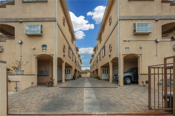 Outdoor view of a multi-story building with covered parking spaces.