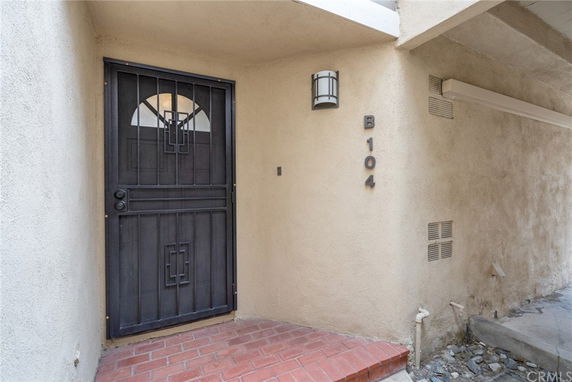 Front view of a building entrance with a metal security door labeled B104.