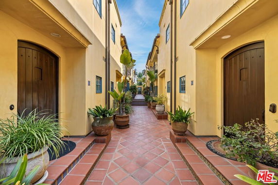 Front view of a narrow alley with Mediterranean-style townhouse entrances.