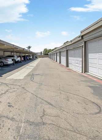 Outdoor parking area with covered parking spaces and garages.