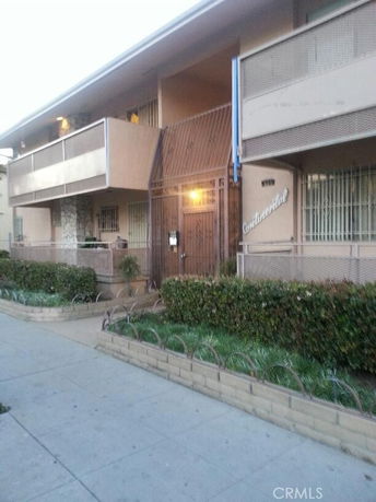 Front view of a two-story building with balconies and a gated entrance.