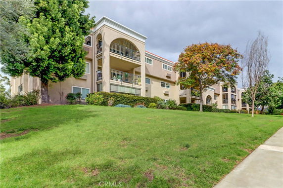 Front view of a multi-story apartment building with balconies.