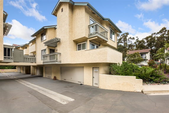 Front view of a multi-story building with beige exterior and small balconies.