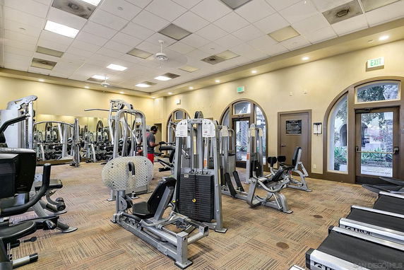 Indoor gym area with various exercise equipment and machines.