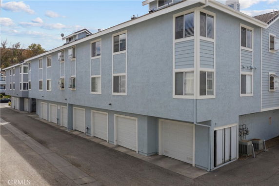 Front view of a multi-story building with multiple garages at the ground level.