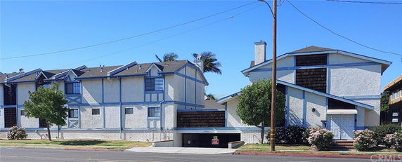 Front view of a multi-story residential building with a gable roof and blue trim.
