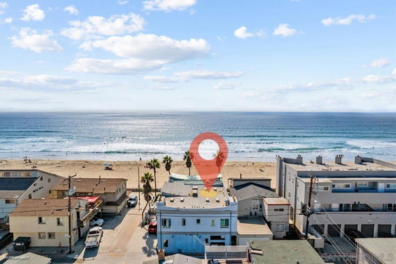 Aerial view of beachfront buildings with the ocean in the background.
