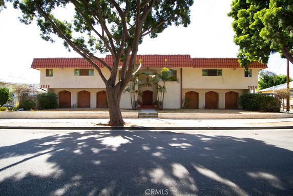 Front view of a two-story building with a red tiled roof and multiple arched doorways.