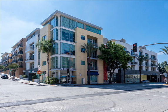 Front view of a modern multi-story building on a street corner.