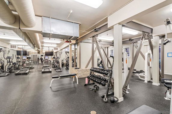 Indoor gym area with exercise equipment and mirrors.