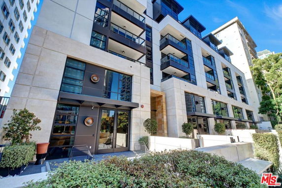 Front view of a modern multi-story building with large windows and balconies.