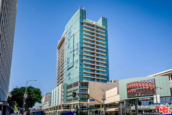 Front view of a modern high-rise building with glass facade and balconies.