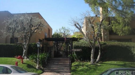 Front view of a two-story building with a gated entrance and stairway.