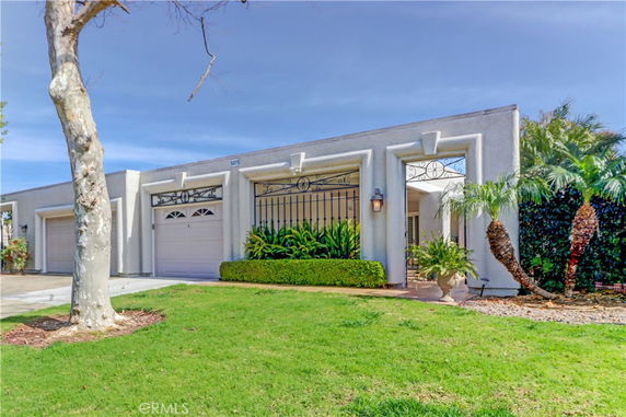 Front view of a house with a double garage and decorative plants.