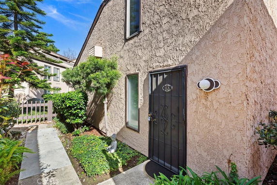 Front view of a house with a textured exterior wall and entrance gate.