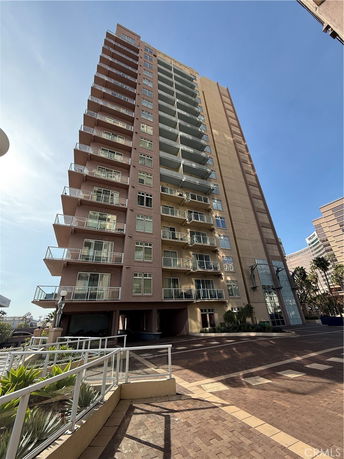 Front view of a tall multi-story apartment building with balconies.