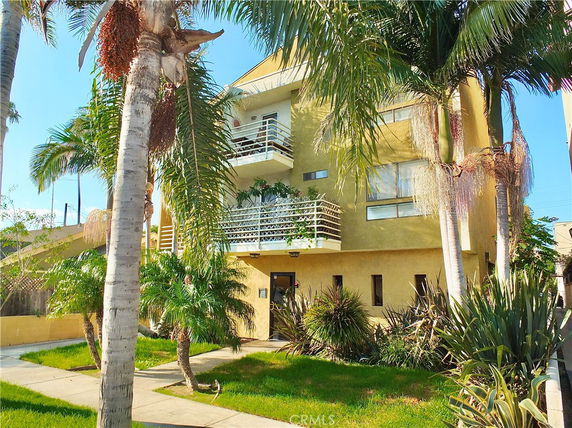 Front view of a multi-story building with balconies and large windows.