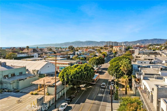 Panoramic view of a neighborhood with roads, buildings, and distant mountains.