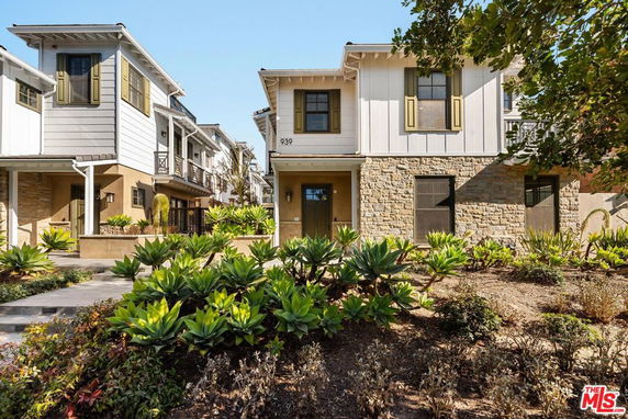 Front view of a multi-story house with stone and siding exterior, featuring shutters on windows.