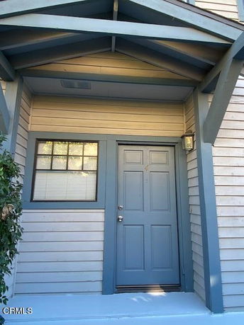 Front view of a house entrance with a blue door and siding.