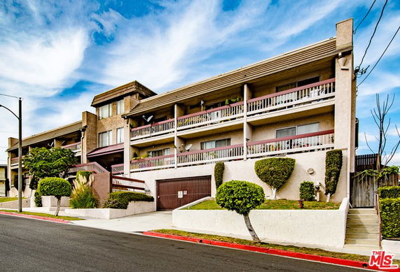 Front view of a multi-story residential building with balconies.