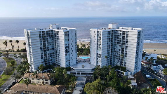 Front view of two high-rise residential buildings near the beach.