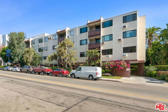 Front view of a multi-story apartment building with balconies.
